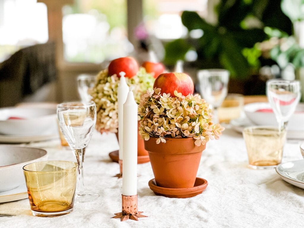 Fall Centerpiece with Apples & Hydrangeas on wood table with candle