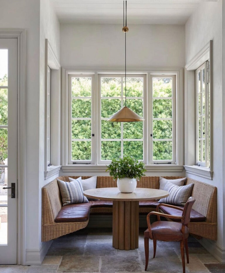 A wicker lamp hangs from the ceiling in a breakfast nook.