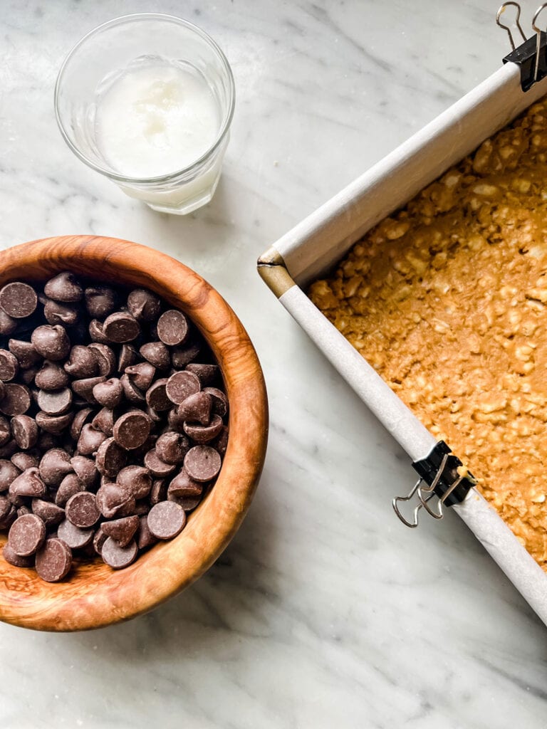 Easy No-Bake Chocolate Peanut Butter Crunch Bars made in a parchment lined 8x8 square cake pan