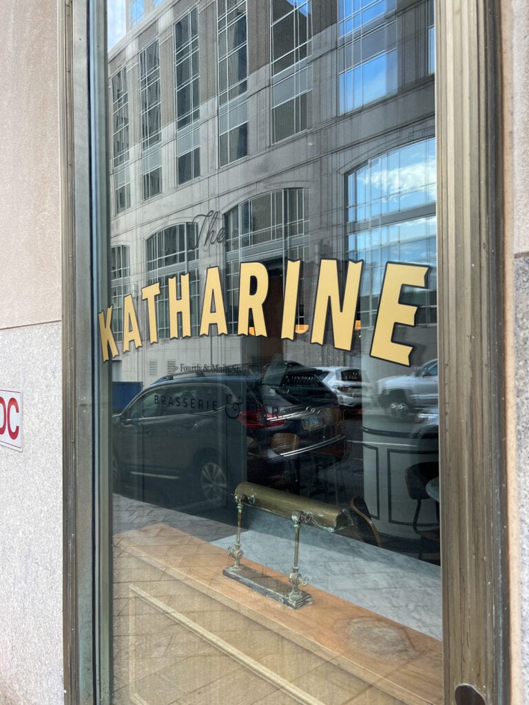 The Katharine at The Kimpton Cardinal gold lettering on glass window