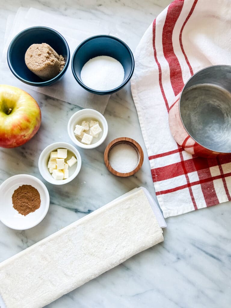 Ingredients in bowls on marble counter for Upside-Down Apple Puff Pastry Tarte