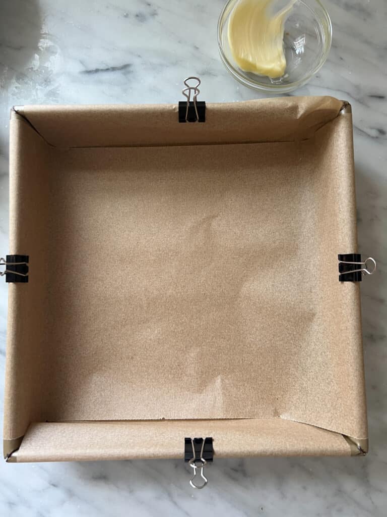 square baling pan with parchment paper and binder clips