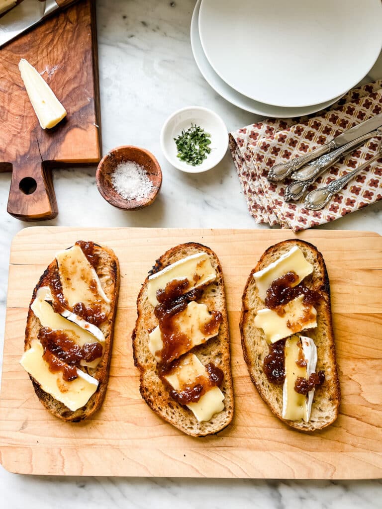 Make this Easy & Delicious Creme Brûlée Brie Tartine, 3 slices of toast with Brie cheese on wood cutting board