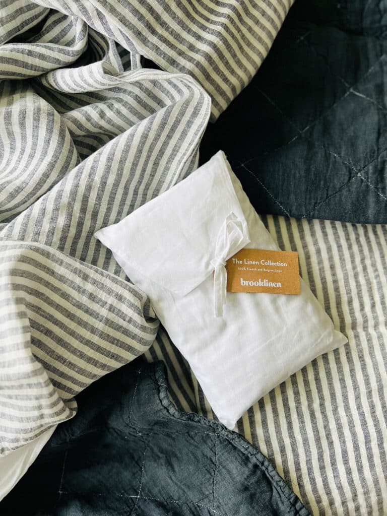 linen strip and black quilt bedding with tag on white bag