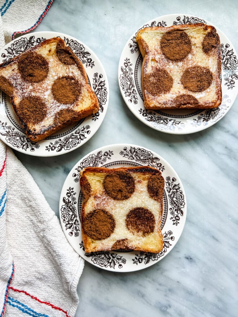 How to make the most delicious cinnamon sugar toast  - three small plates with toast where the cinnamon is in a polkadot pattern creating brown circles on top 