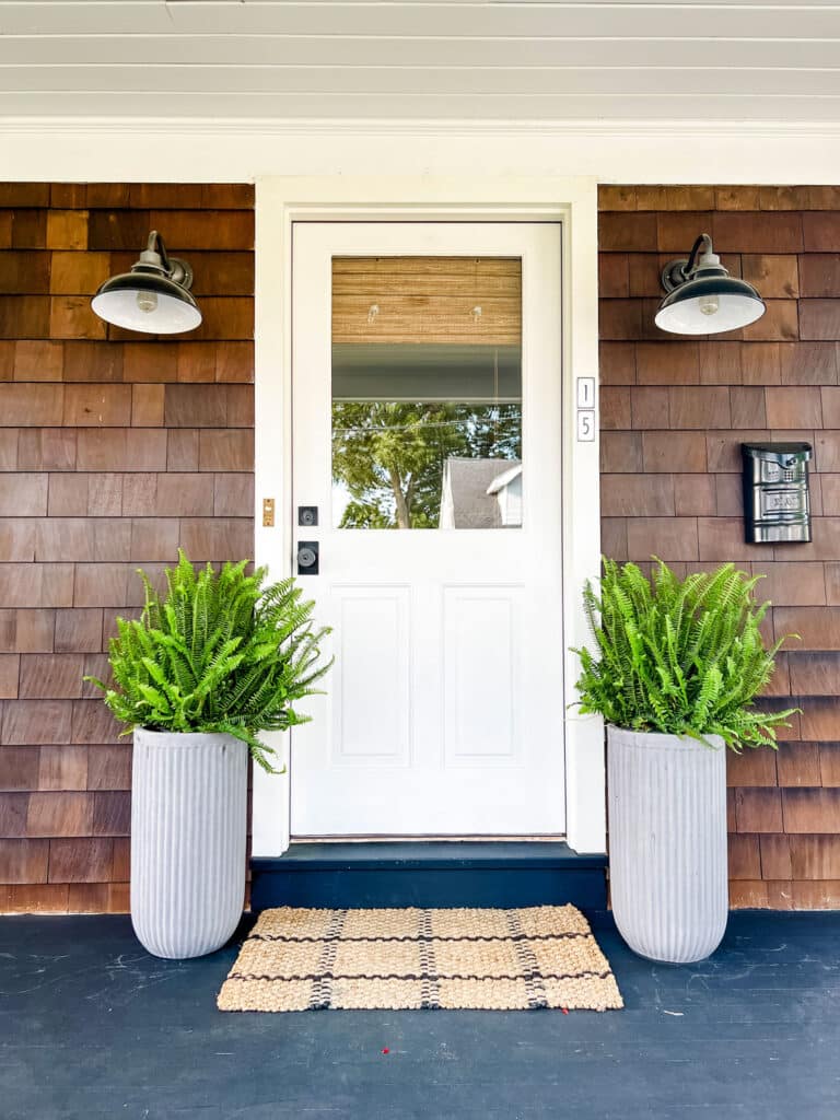 cottage style home with ferns in tall planters 