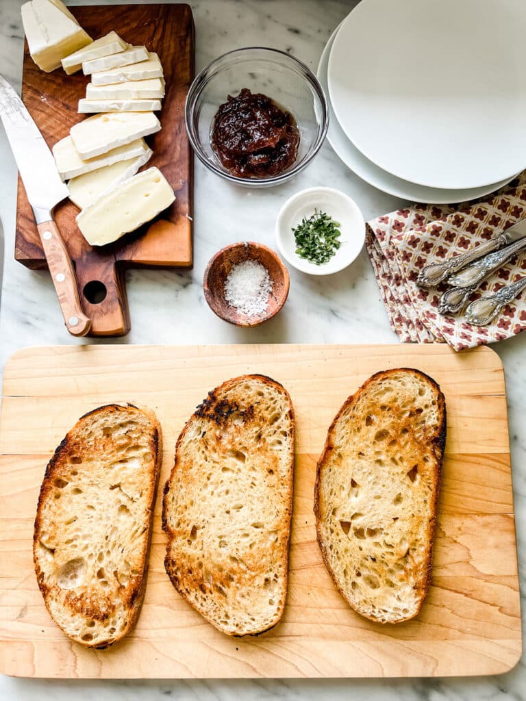Make this Easy & Delicious Creme Brûlée Brie Tartine, 3 slices of toast one wood cutting board