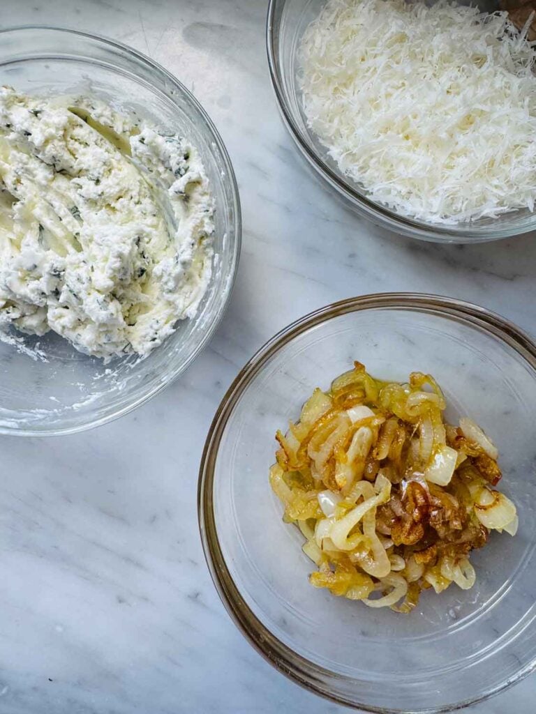 In small bowls, you have caramelized shallots, herbed goat cheese, and shredded parmesan cheese.