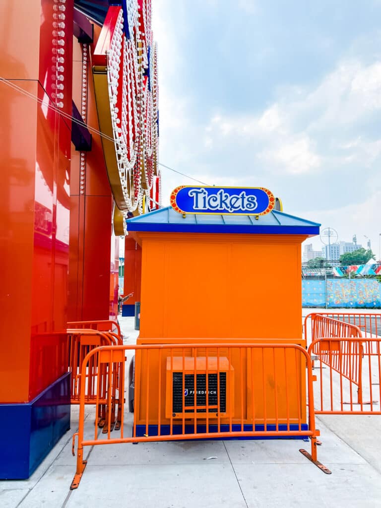 Orange ticket booth with blue sign at Coney Island Why Coney Island, New York City is Worth a Visit