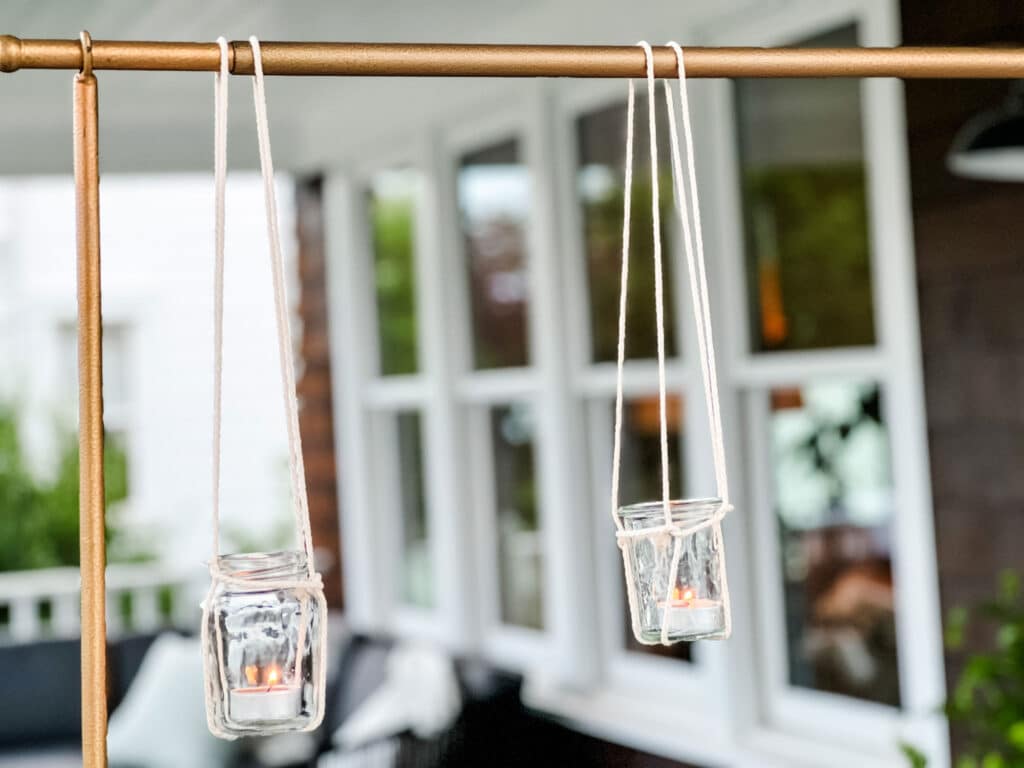 glass jars hanging with votive from gold rod 
