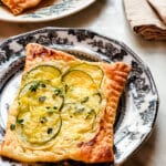 puff pastry tart with zucchini on black ironstone vintage plate