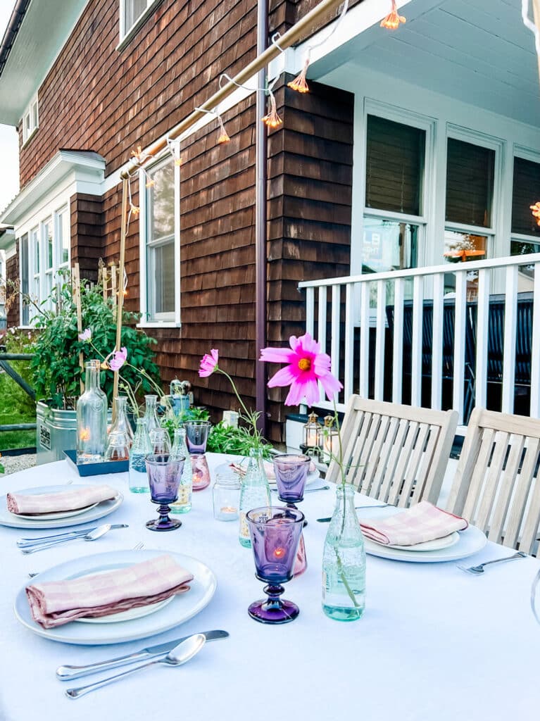 How to create a simple garden party - choose glassware that's inspired by the color of your flowers. Pink Cosmos in bottles 