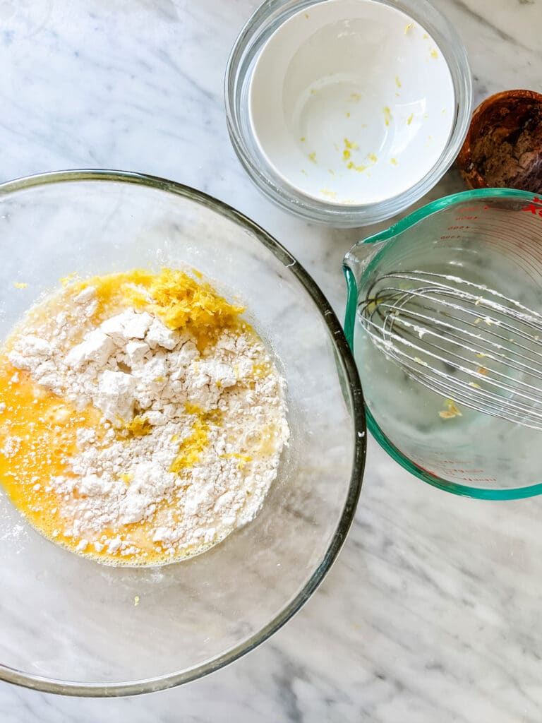 bowl with lemon mixture with flour, whisk in measuring cup