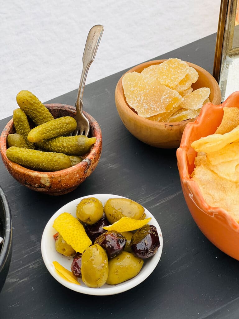 Olives, cornichons, dried fruit on black farmtable plank
