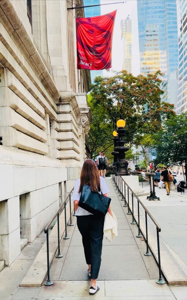 woman with long brown haor walking up the ramp at NYPL