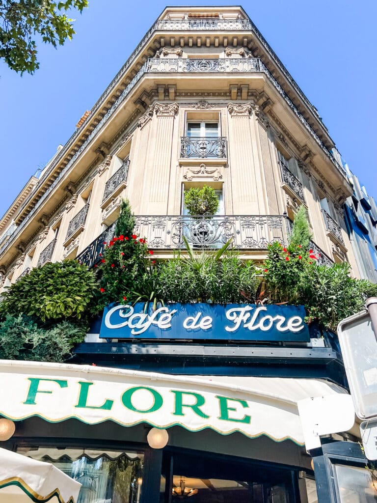 A building with the Cafe de Flore sign and signature white awning where you can order a traditional taste of Paris with the Croque Monsieur.