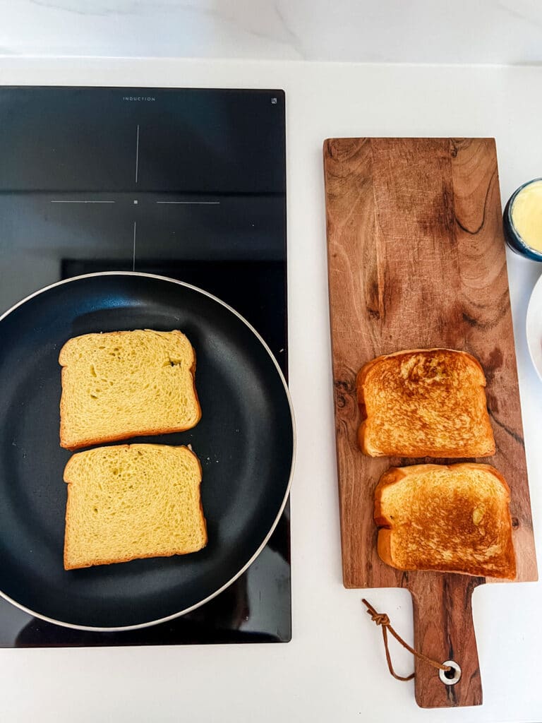 Country bread toasting in a frying pan for a traditional Croque Monsieur