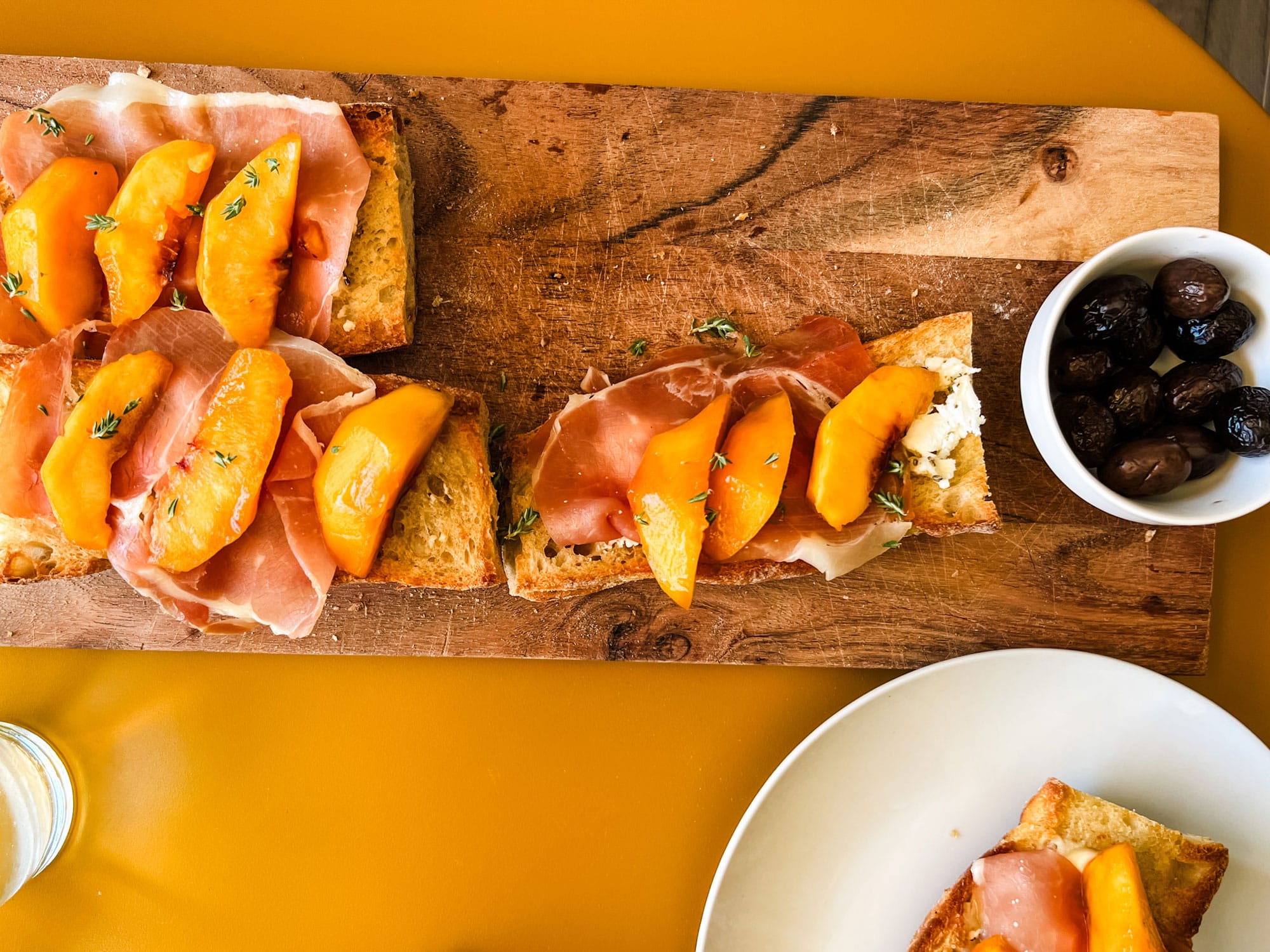 https://mostlovelythings.com/wp-content/uploads/2023/09/peach-ham-tartine-on-wood-board-with-dish-of-olives.jpg