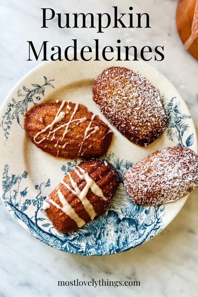 4 Madeleines on a small blue and white plate. 2 are glazed and 2 are topped with powdered sugar.