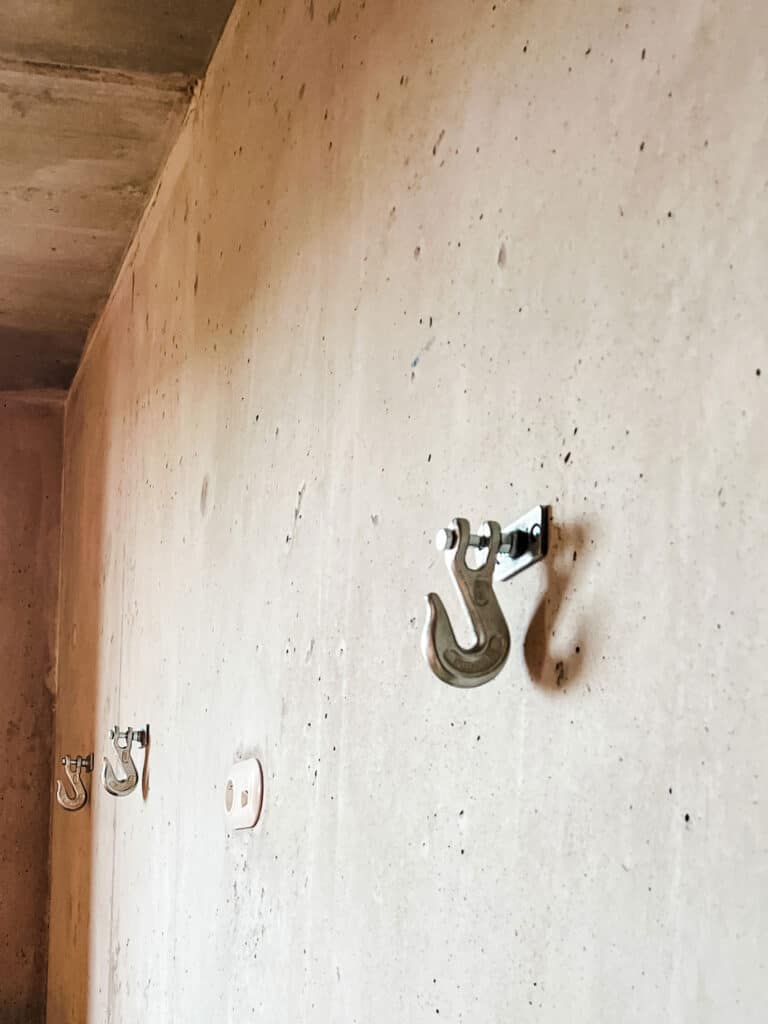 Steel industrial wall hooks are mounted on concrete walls at the Mob House Hotel Paris.