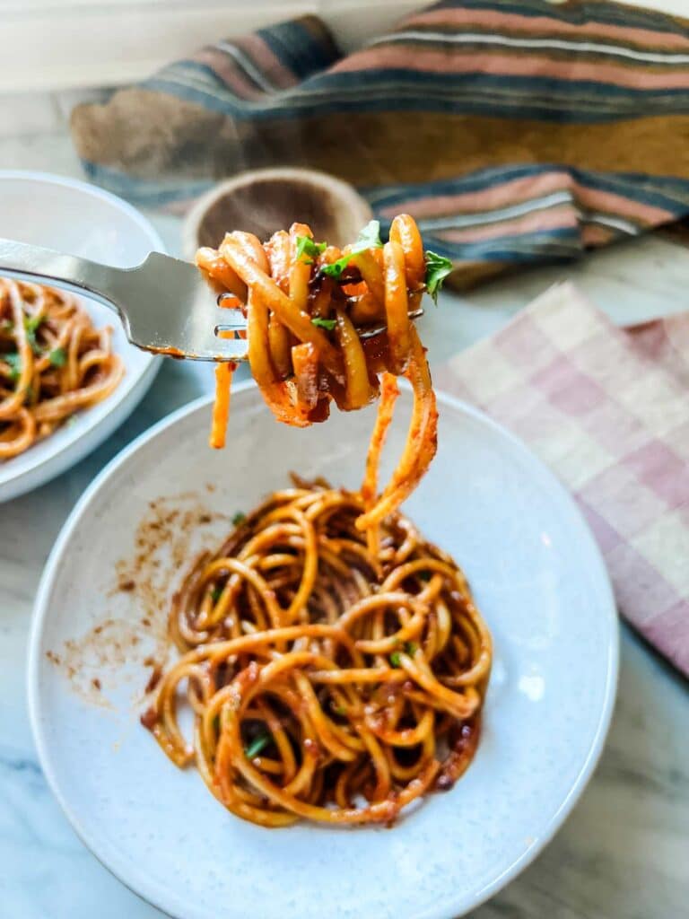 Shallot pasta in a bowl with a fork of pasta ready to be eaten.