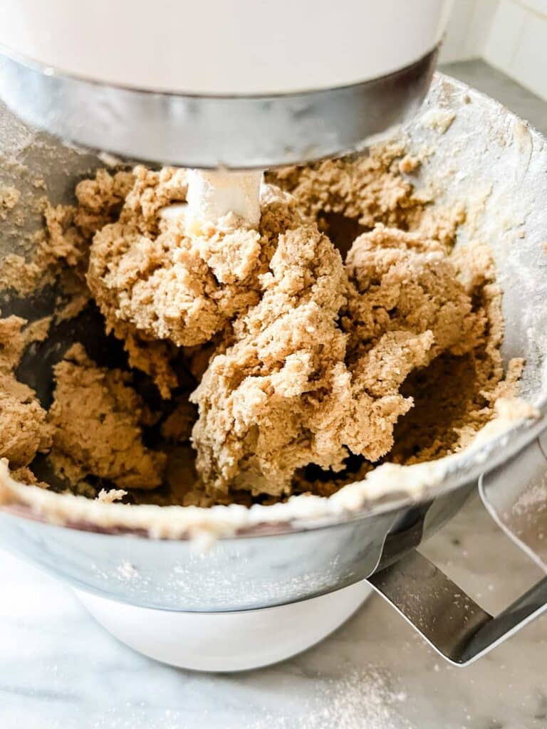 In a stand mixer, the dry ingredients have been mixed with wet ingredients to form the dough for soft and chewy apple pie thumbprint cookies.