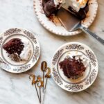 Tow slices of hot chocolate bundt cake are served on small vintage french plates. Next to the plates are the numbers 2025.