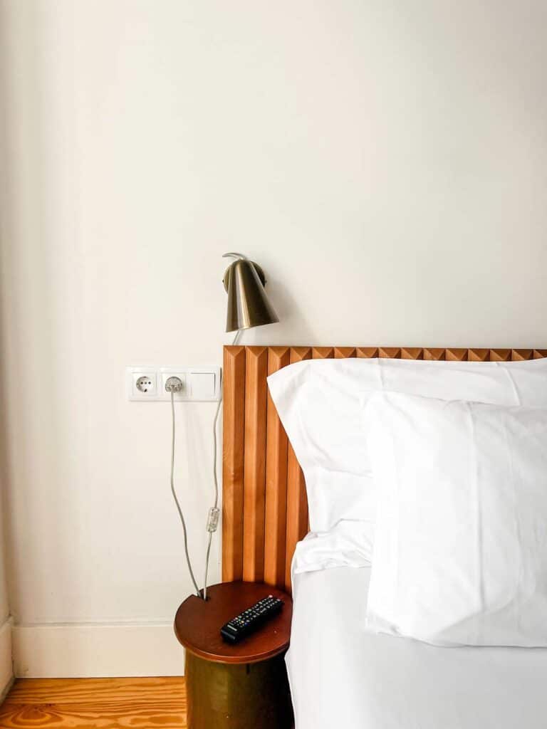 bed with crisp white linens and small sconce 