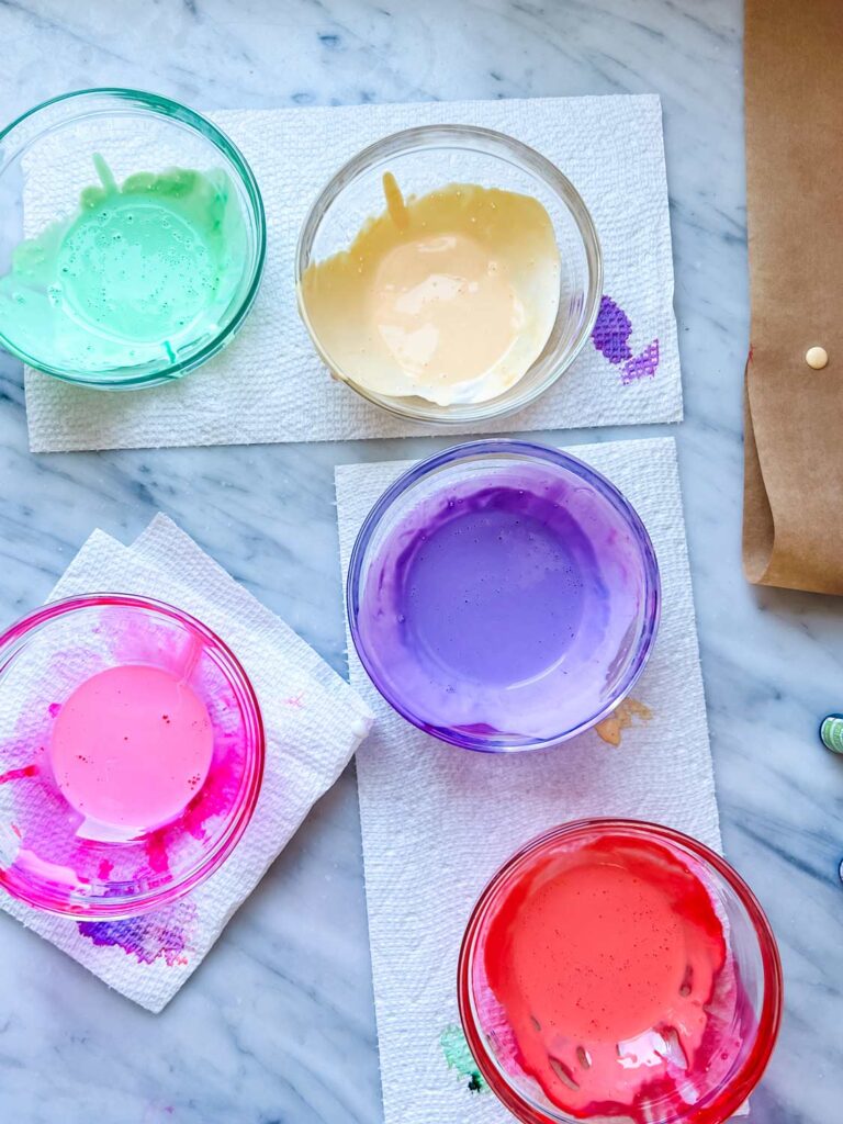 Mixed paints in green, yellow, purple, red and pink for making candy-colored glass jars for Valentine's Day.