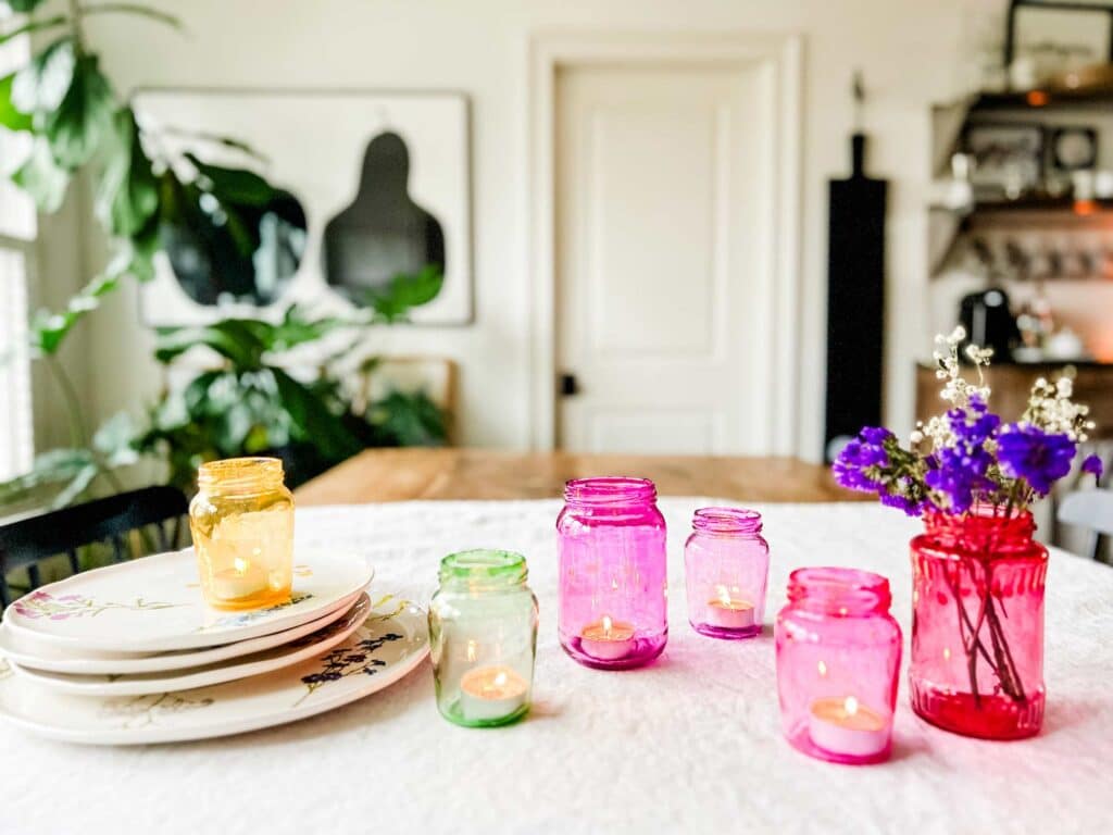 How to make candy-colored glass jars for Valentine's Day is a fun project. Here are six colored jars ready for making a fun tablescape.
