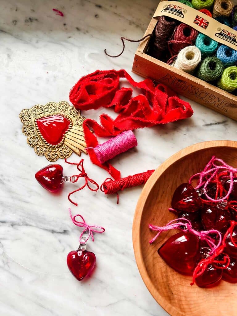 Red heart ornaments, crate of colored twine, heart, velvet ribbon 