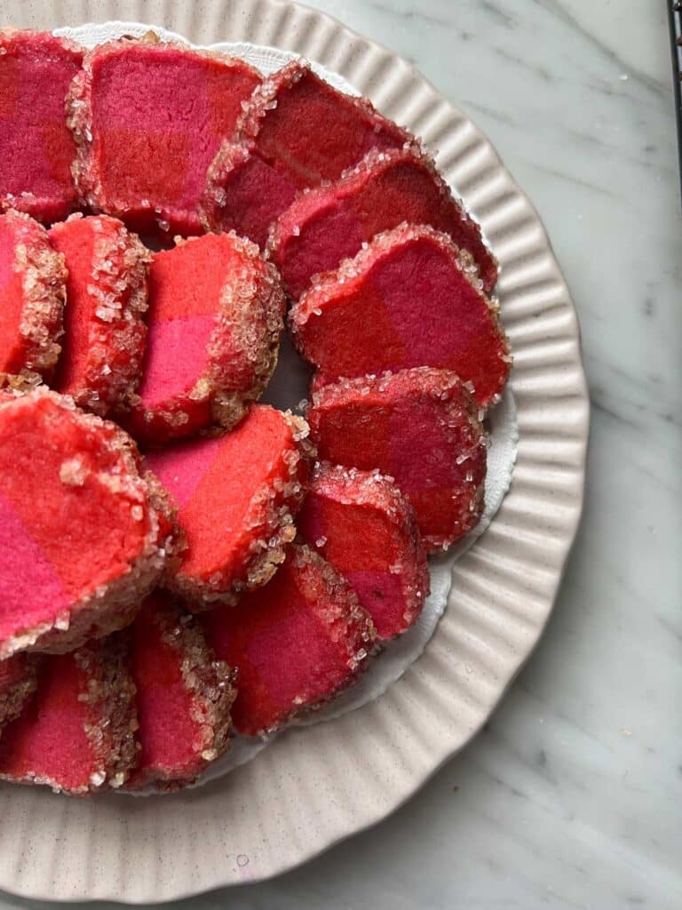 pink and red shortbread cookies on a light pink plate 