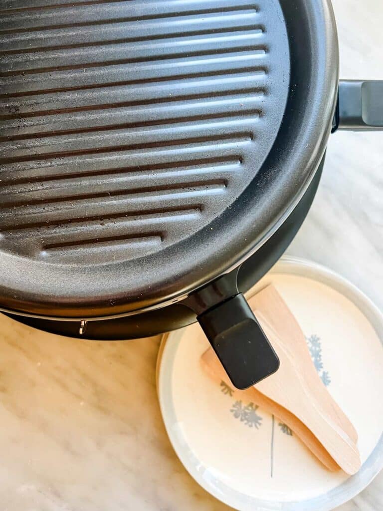 A full-sized Raclette machine with a grill on top for chicken, beef, shrimp, or sausage.