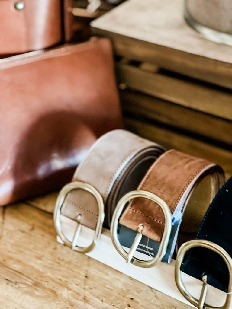 The lovely belts are displayed perfectly on a wooden table.