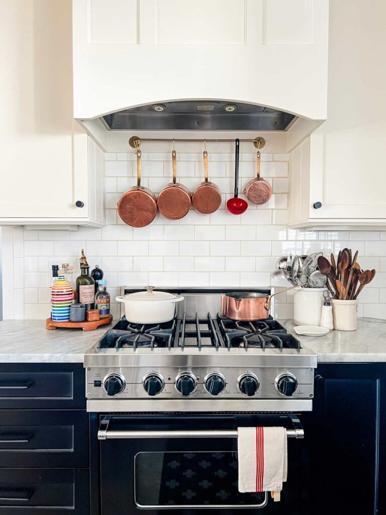 A red ladle next to copper pans show the unexpected red theory in home design.