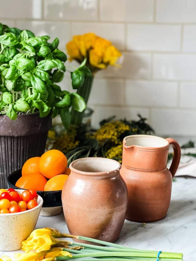Simple ideas on how to refresh your home for spring include vintage vases, fresh flowers, and fruit.