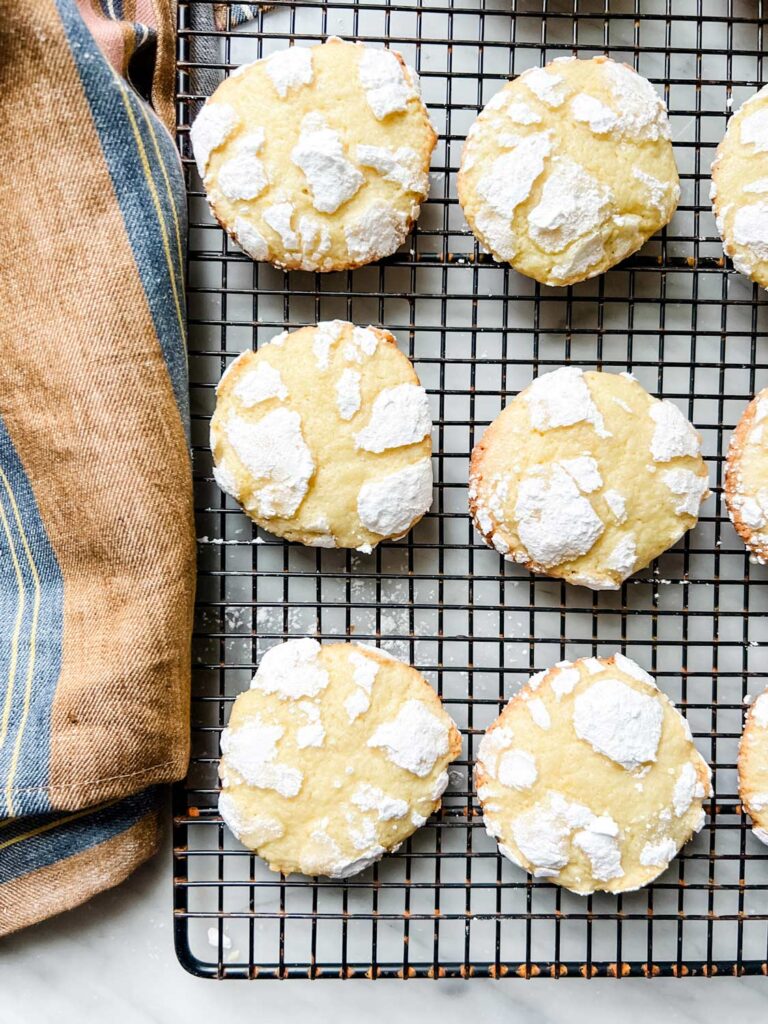 Lemon crinkle cookies have been baked and are cooling on a wire rack.