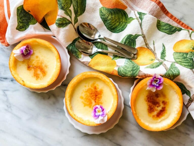 Orange posset with brûlée topping is served in hollowed out orange peels.