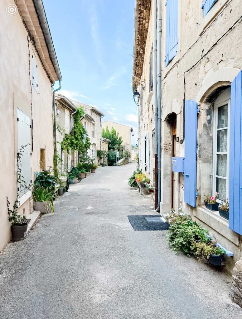 A small cobblestone street winds its way through houses in the small village of Grignan, France.