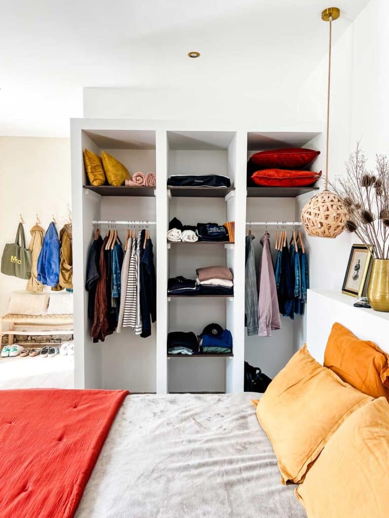 Open closet space is featured In the bedroom of this Airbnb in Provence, France.