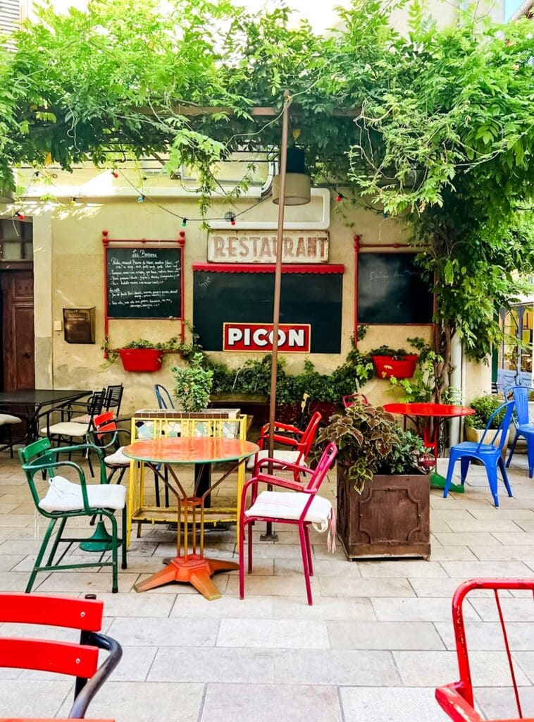 A small restaurant with tables and colorful chairs out front is just one of the many places to stop for a drink or a bite to eat.