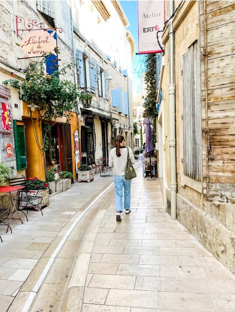 A woman is walking the stone streets on her way to the open-air market in the Provence village of Saint Rémy.