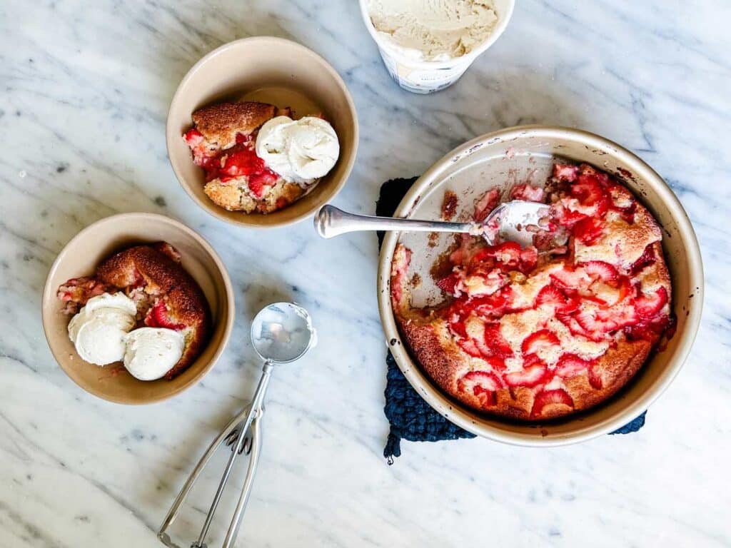 A surprisingly simple summer strawberry spoon cake recipe is a great summertime dessert served with scoops of vanilla ice cream.