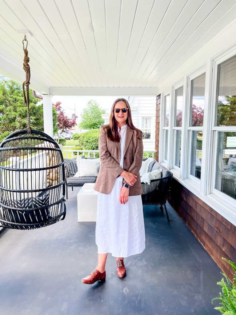 A 2-piece white dress (skirt and shirt) from Eileen Fisher paired with a wool blazer from J.McLaughlin. Sun glasses from Quince.