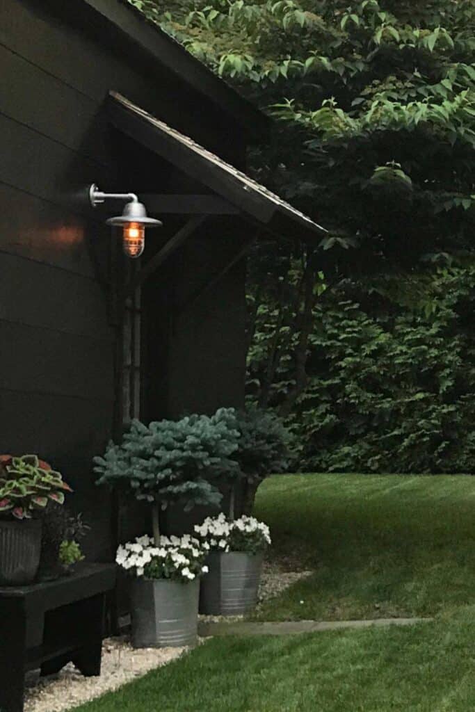 A sconce on the side of a garage provides a nice glow at dusk.