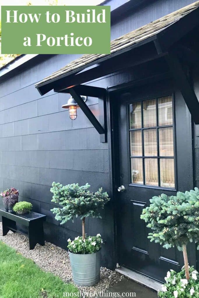 A garage side door with a DIY portico, sconce and plantings in galvanized steel containers.