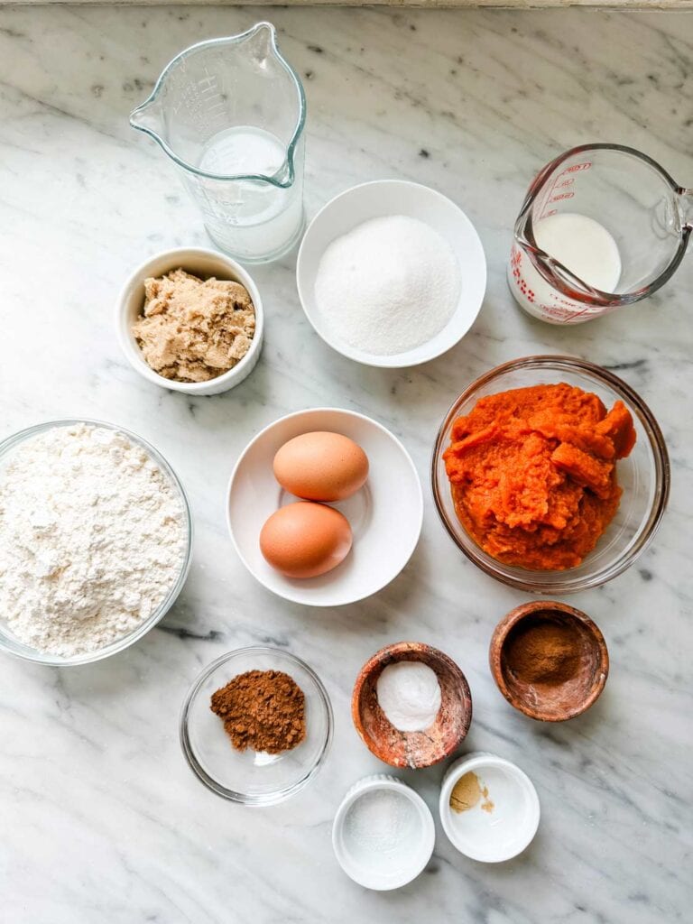 All the ingredients to make pumpkin spice muffins have been measured and placed in different containers.