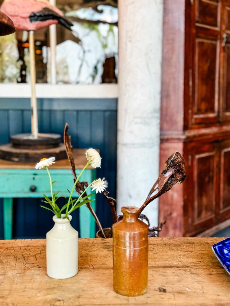 tiny vases of foraged flowers on distressed table top