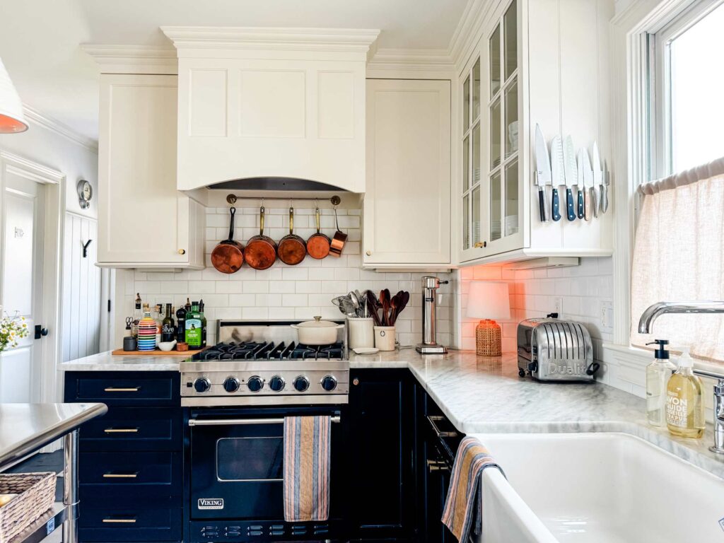 Black Viking range, white cabinets, toaster, lamp, copper pots.