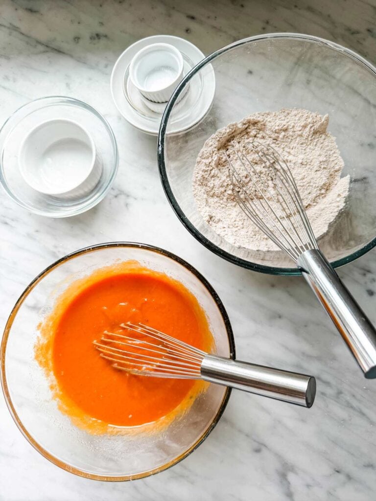 Dry and wet ingredients are mixed in separate bowls and are ready to be combined into muffin batter.